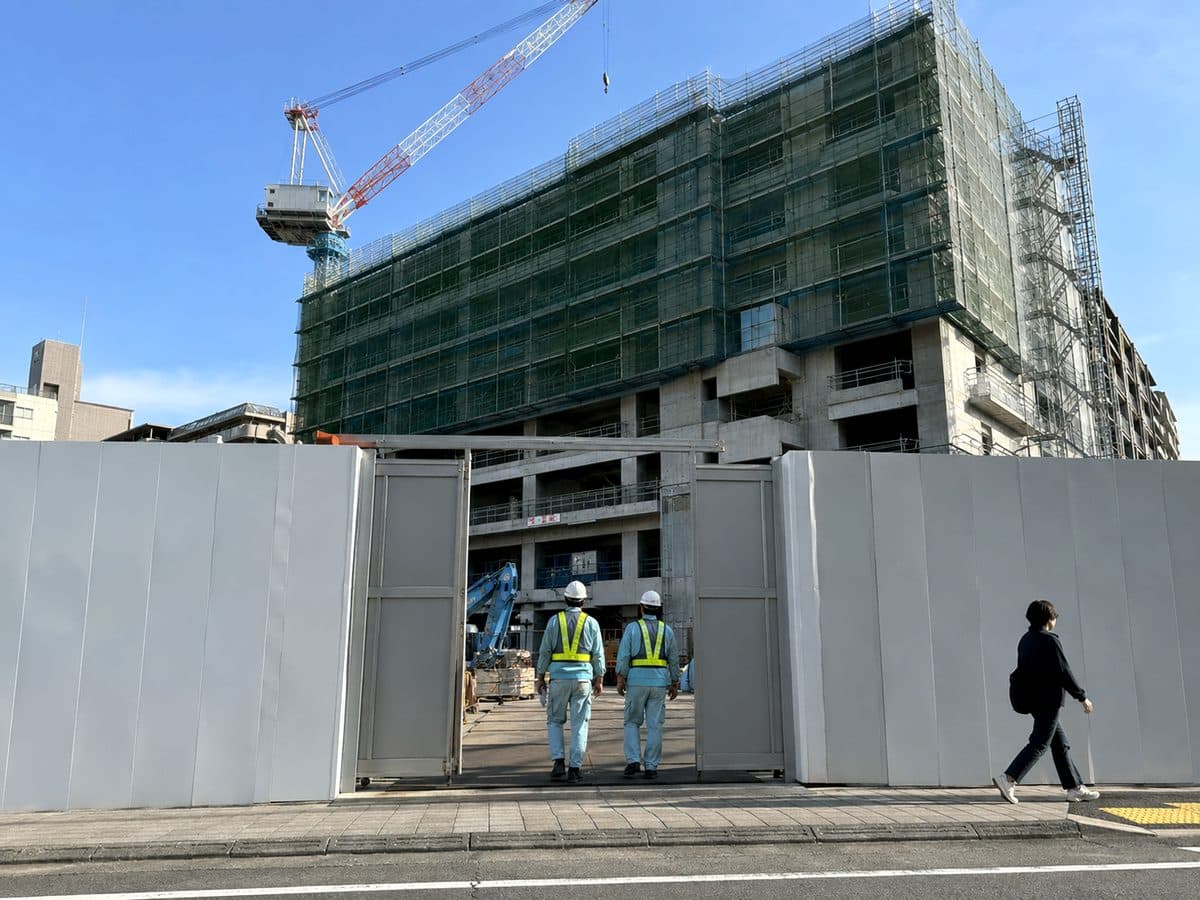 仮囲いとアルミゲートで囲まれた市街地のマンション新築工事現場のイメージ