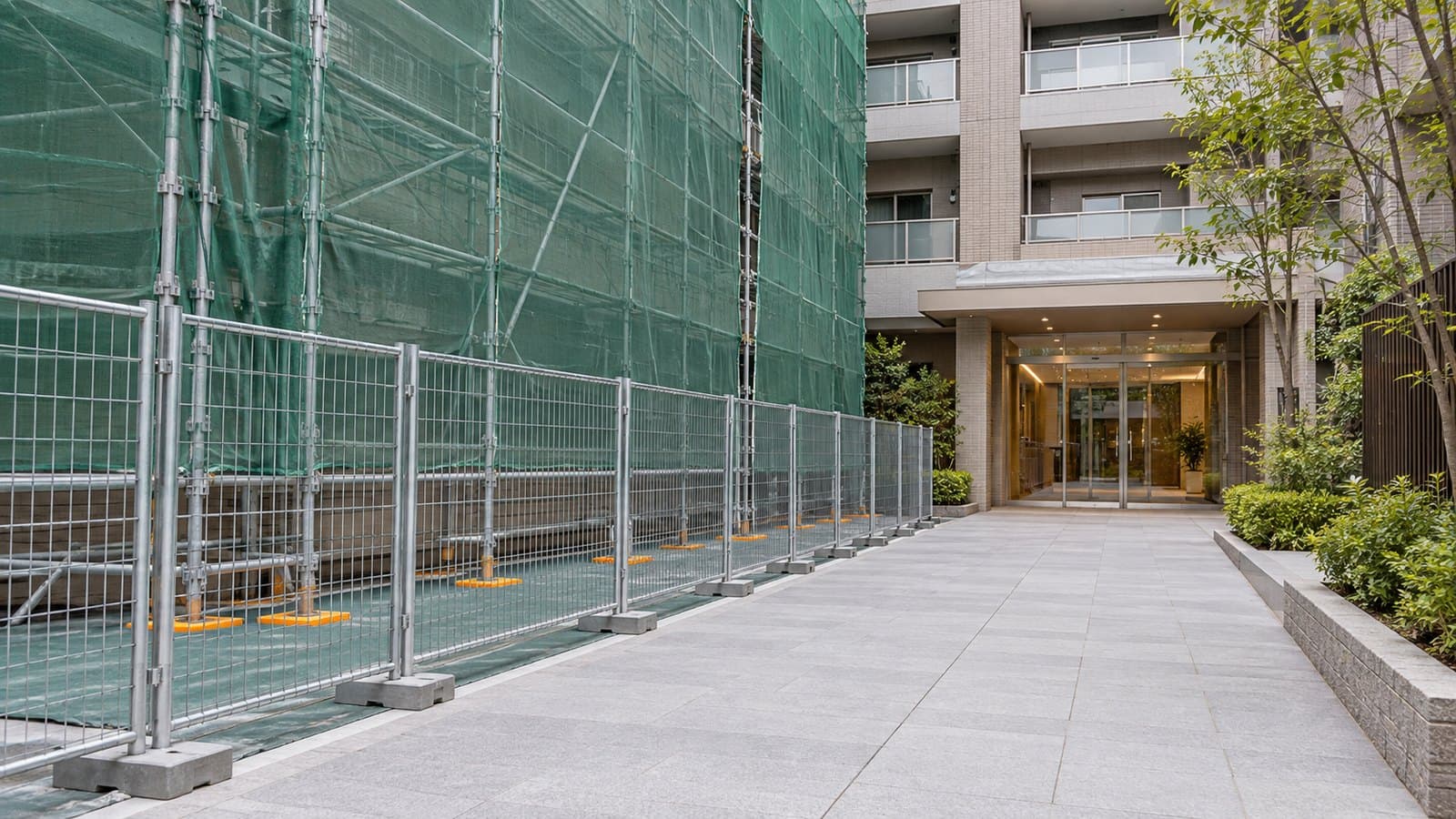 仮設フェンスの外側に建物入口への通路を確保した外壁改修のイメージ