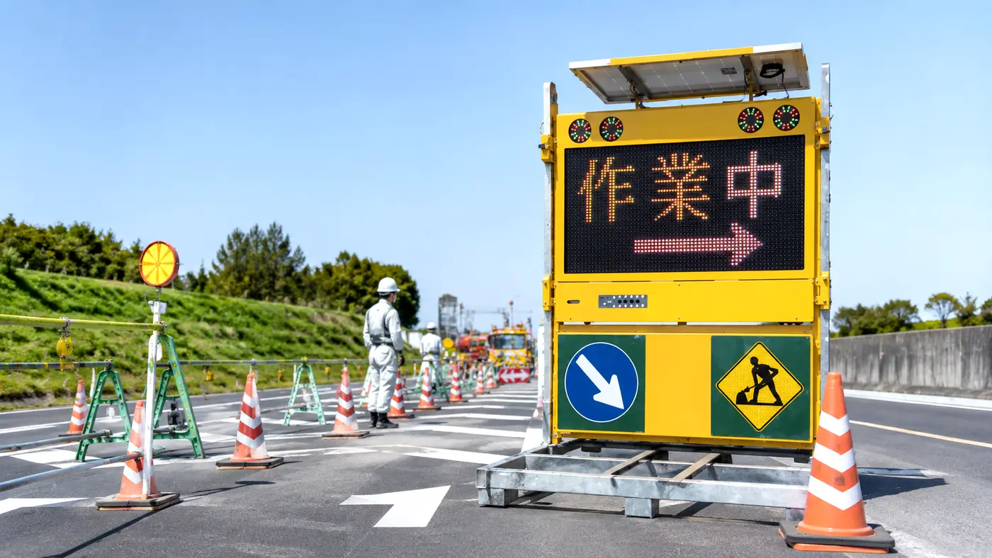 道路工事現場に設置されたソーラー式電光標示板「作業中」表示